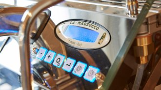 Perspektivische Detailansicht einer Kaffemaschine der Marke La Marzocco aus Florenz/Italien – sie ist Teil der Work-Kitchen im Showroom der offino Bürolösungen GmbH in Kempten. 